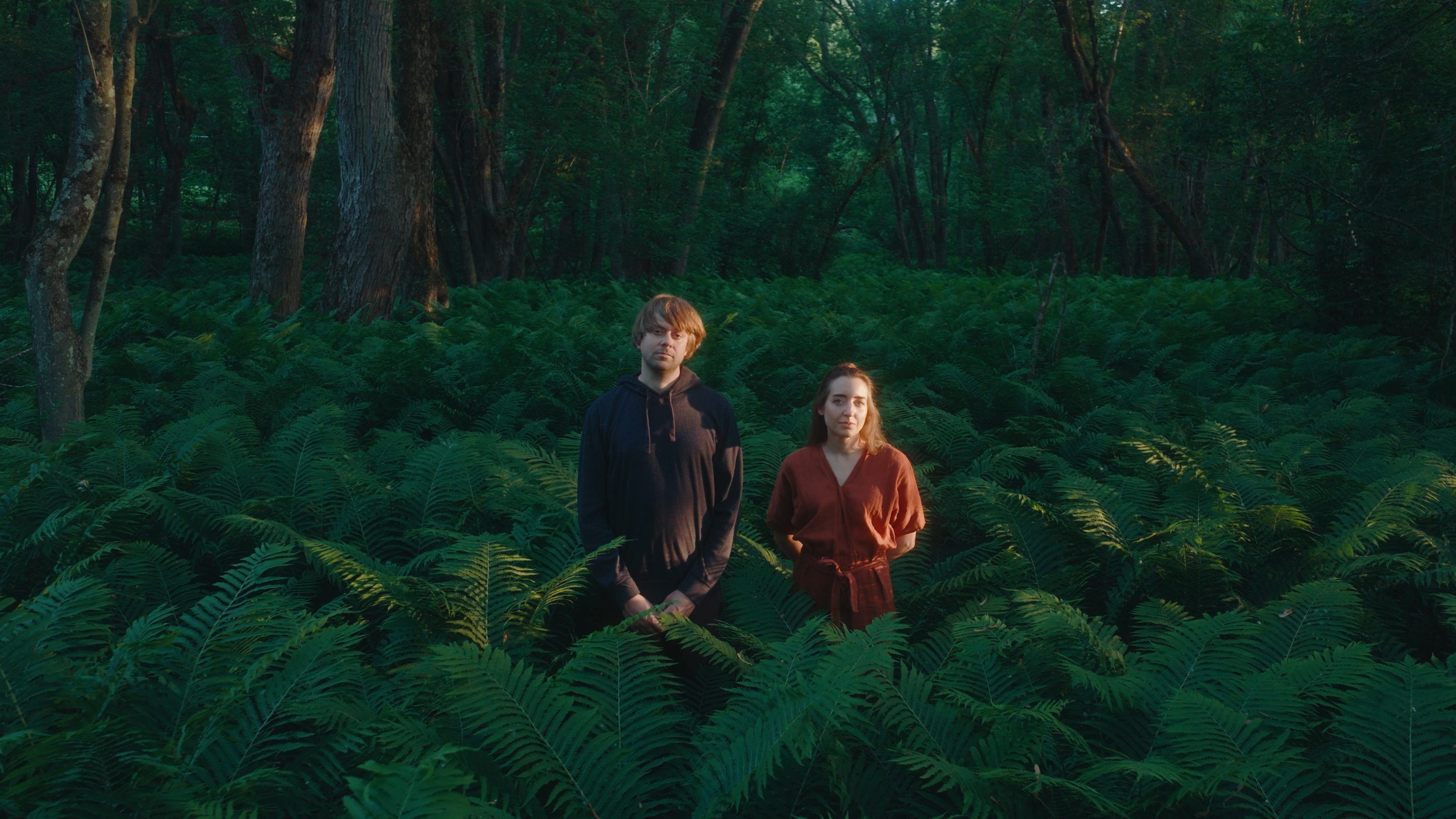 Taylor Smith and Laura Heaberlin of Cricket Blue standing in a fern forest. Credit: Connor Gallagher and Joe Rittling